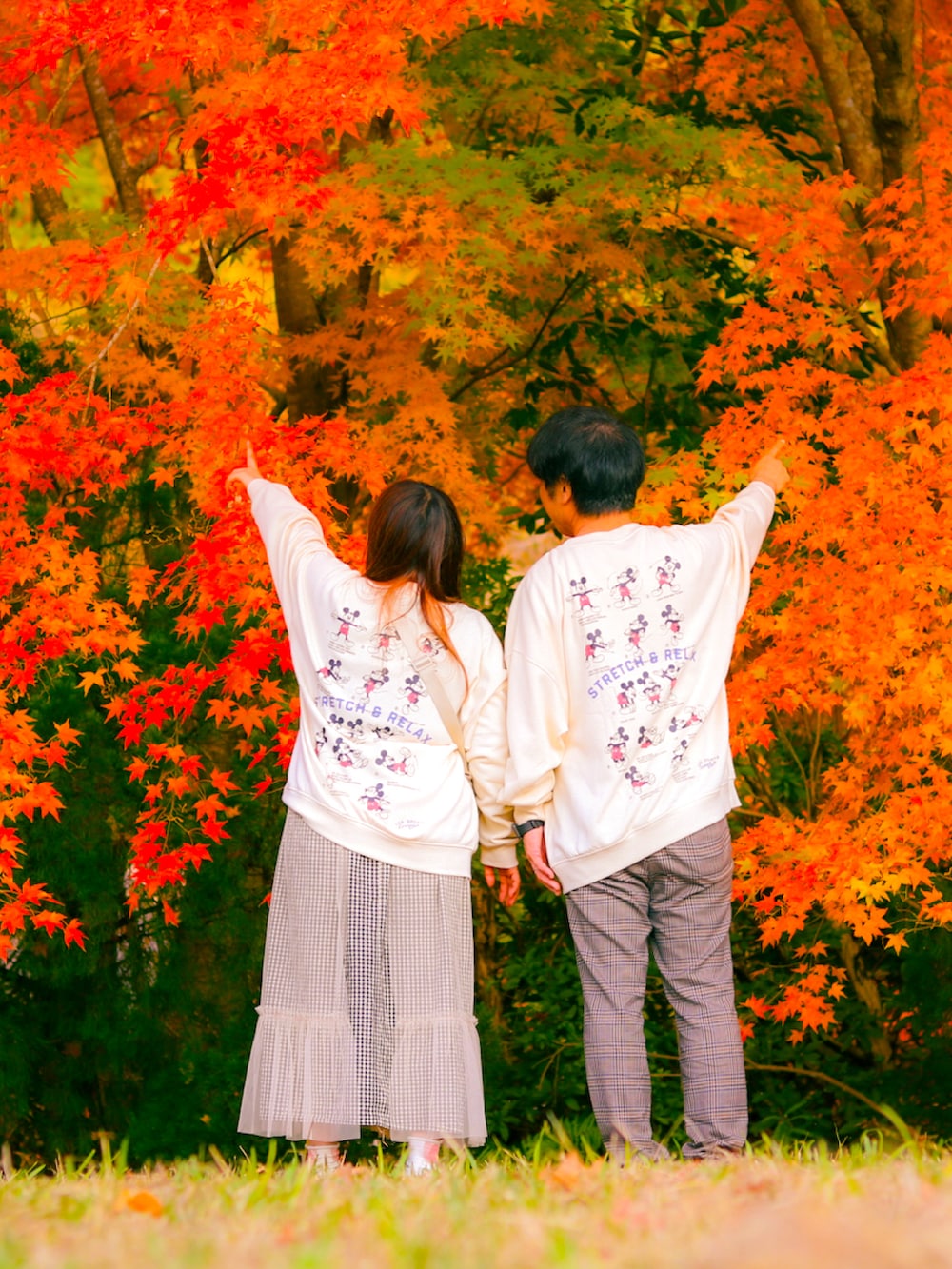 グレー系のパンツ、ブラック系のドレスシューズ、ホワイト系のスカートを着用したレディースの秋コーディネートの2枚目の写真