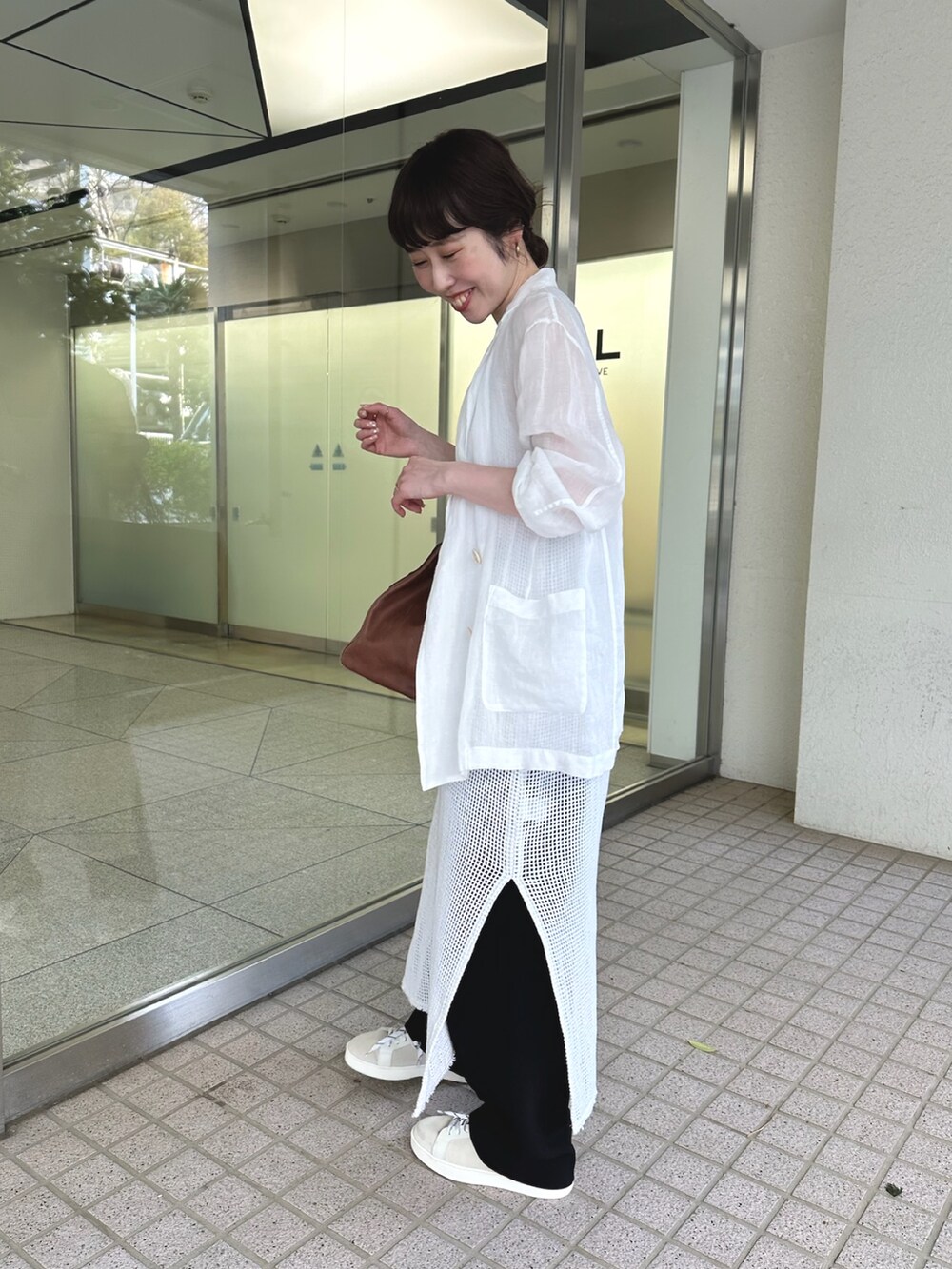 ホワイト系のテーラードジャケット、イエロー系のボストンバッグ、ホワイト系のスニーカーを着用したレディースの春コーディネートの4枚目の写真