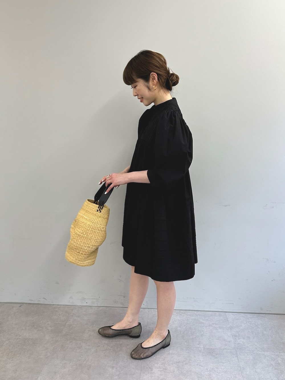 ブラック系のワンピース、ブラック系のパンプスを着用したレディースの春コーディネートの2枚目の写真