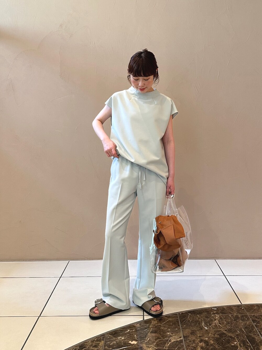 グレー系のシャツ/ブラウス、ブラック系のトートバッグを着用したレディースの夏コーディネートの3枚目の写真