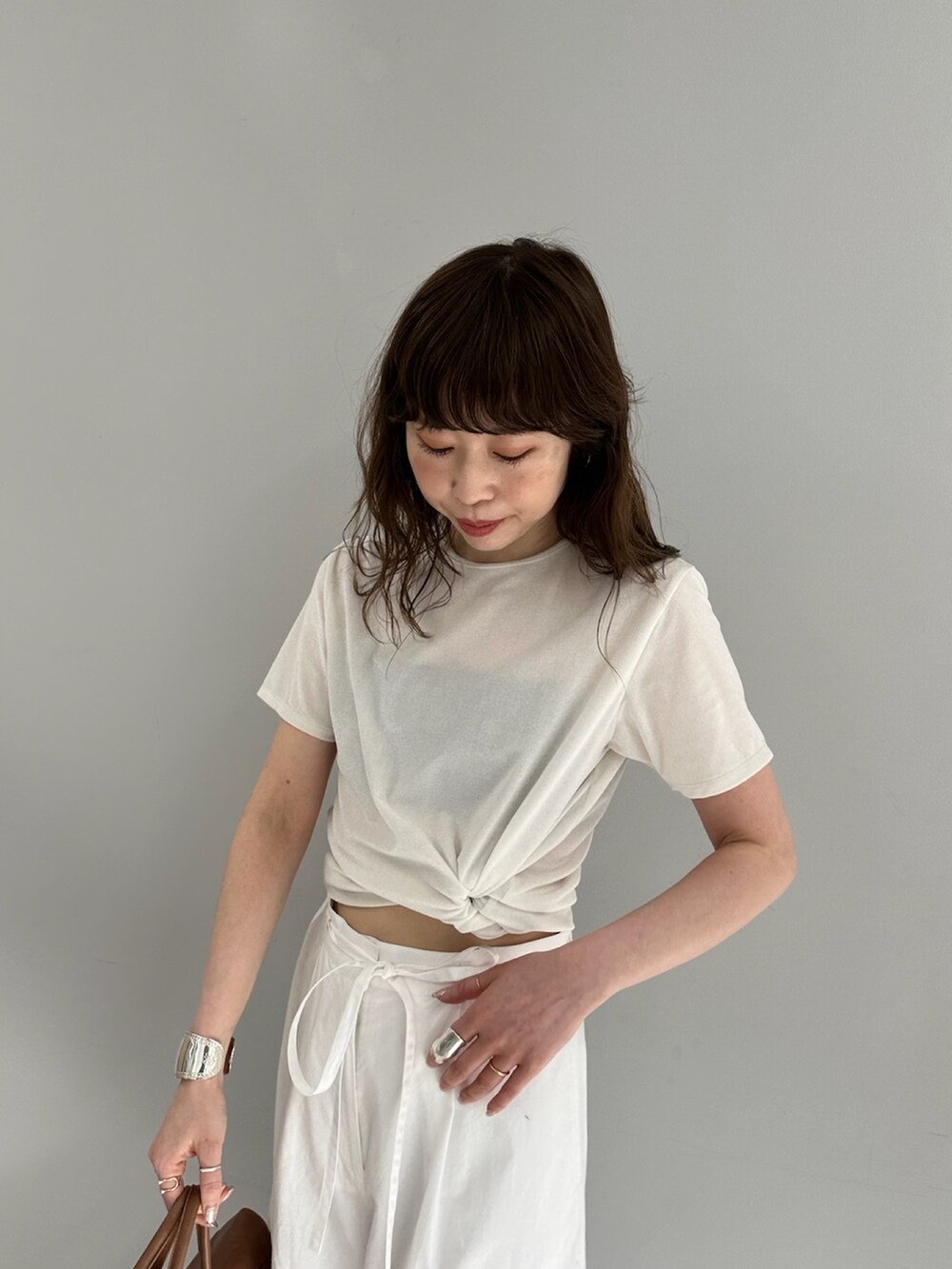 ホワイト系のカーゴパンツ、イエロー系のボストンバッグ、ホワイト系のTシャツ/カットソーを着用したレディースの春コーディネートの4枚目の写真