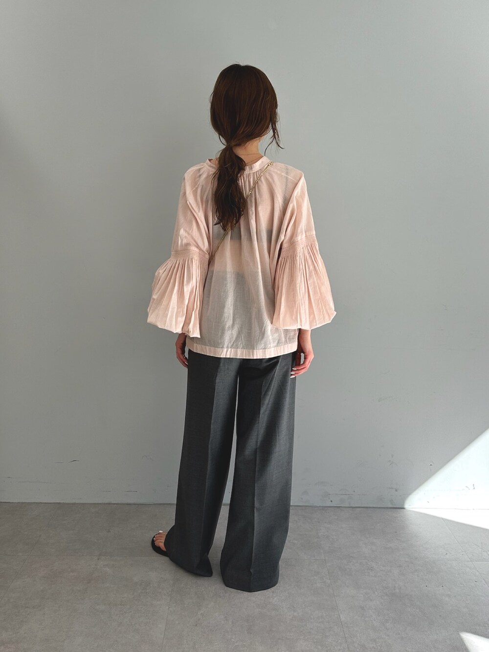 ピンク系のシャツ/ブラウス、グレー系のスラックス、ブラック系のショルダーバッグを着用したレディースの春コーディネートの5枚目の写真