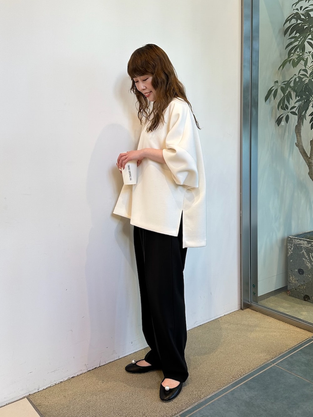 ブラウン系のショルダーバッグ、ホワイト系のTシャツ/カットソーを着用したレディースの春コーディネートの2枚目の写真