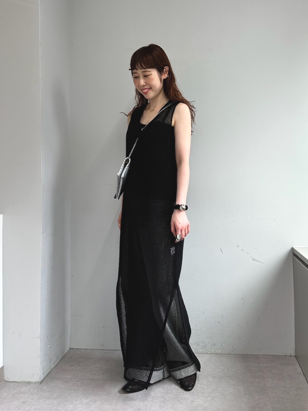 ブラック系のショルダーバッグ、グレー系のデニムパンツを着用したレディースの夏コーディネートの2枚目の写真