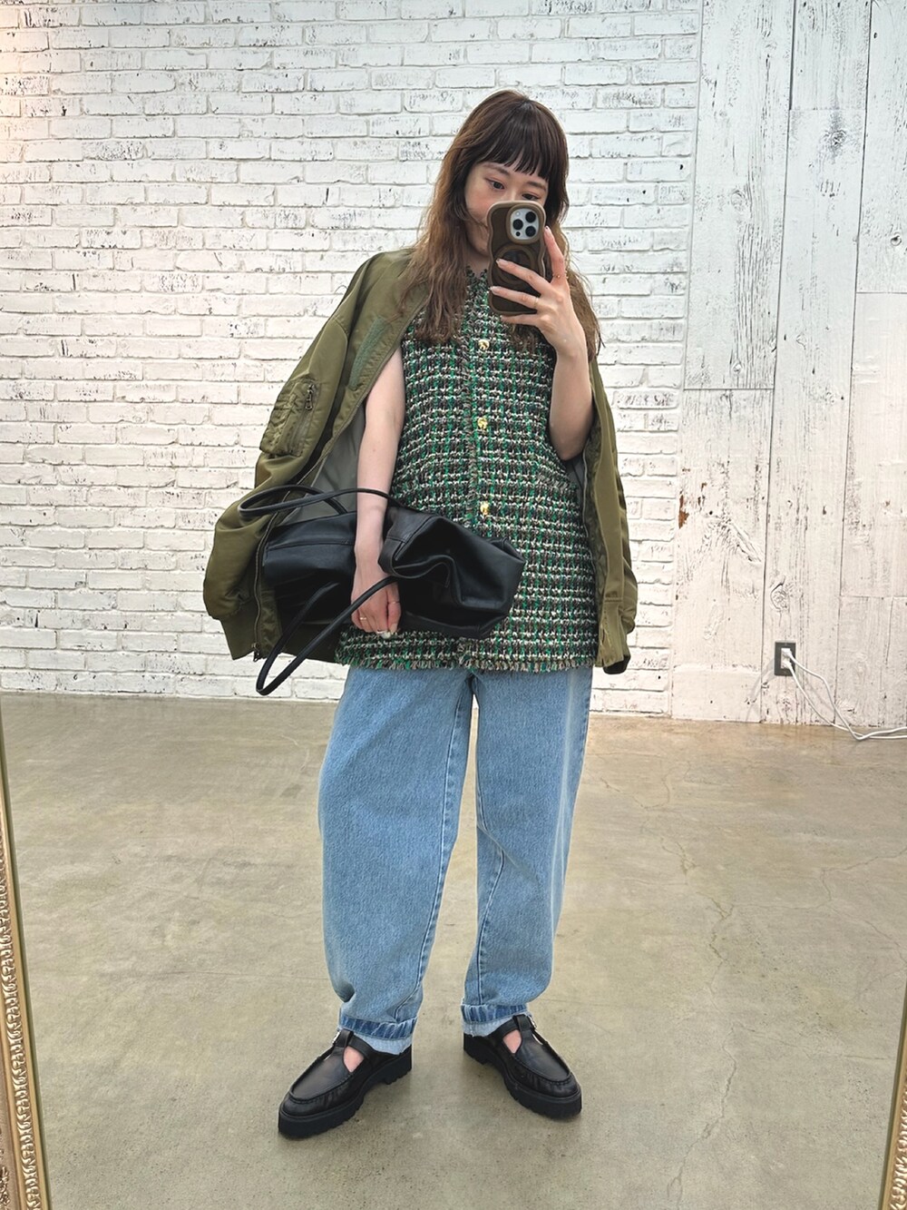 グリーン系のMA-1、ブルー系のデニムパンツ、ブラック系のボストンバッグを着用したレディースの夏コーディネートの6枚目の写真