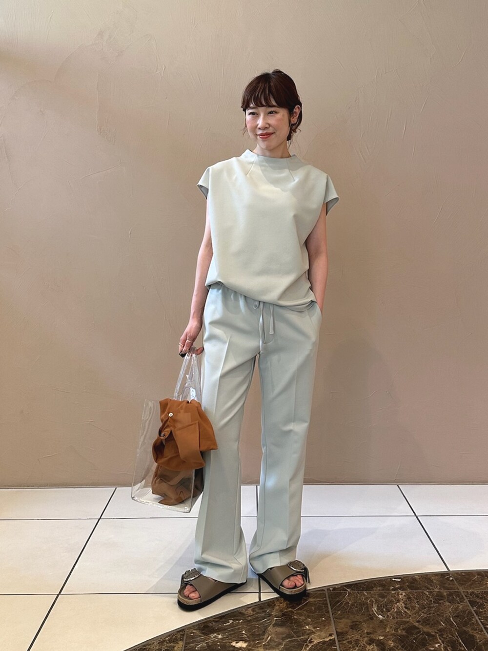 グレー系のシャツ/ブラウス、ブラック系のトートバッグを着用したレディースの夏コーディネートの2枚目の写真