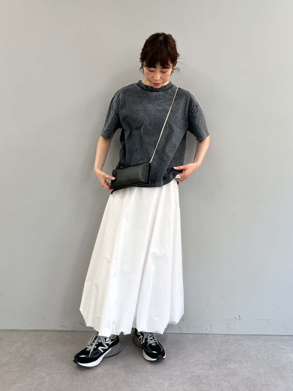 ホワイト系のスカート、グレー系のTシャツ/カットソー、ブラック系のショルダーバッグを着用したレディースの春コーディネートの2枚目の写真