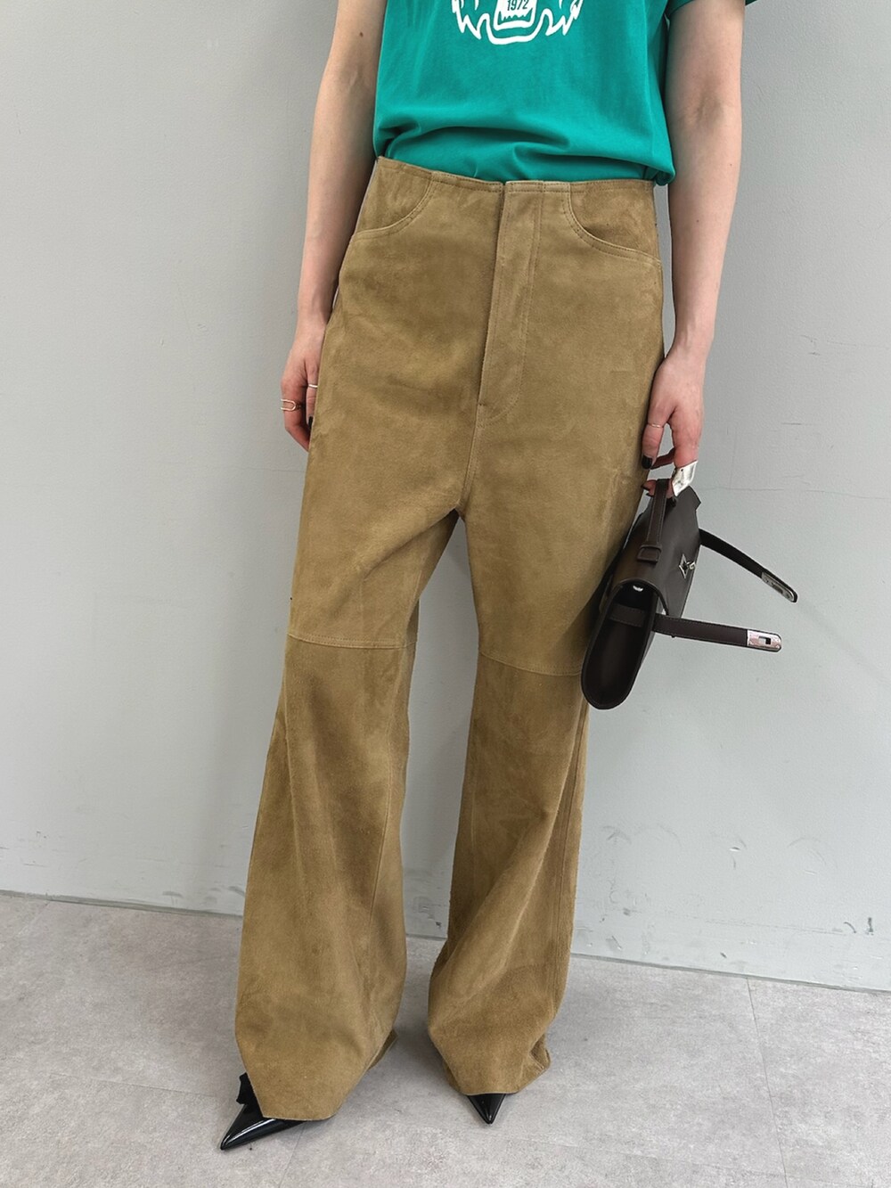 グリーン系のTシャツ/カットソー、イエロー系のその他パンツ、ブラウン系のハンドバッグを着用したレディースの春コーディネートの8枚目の写真