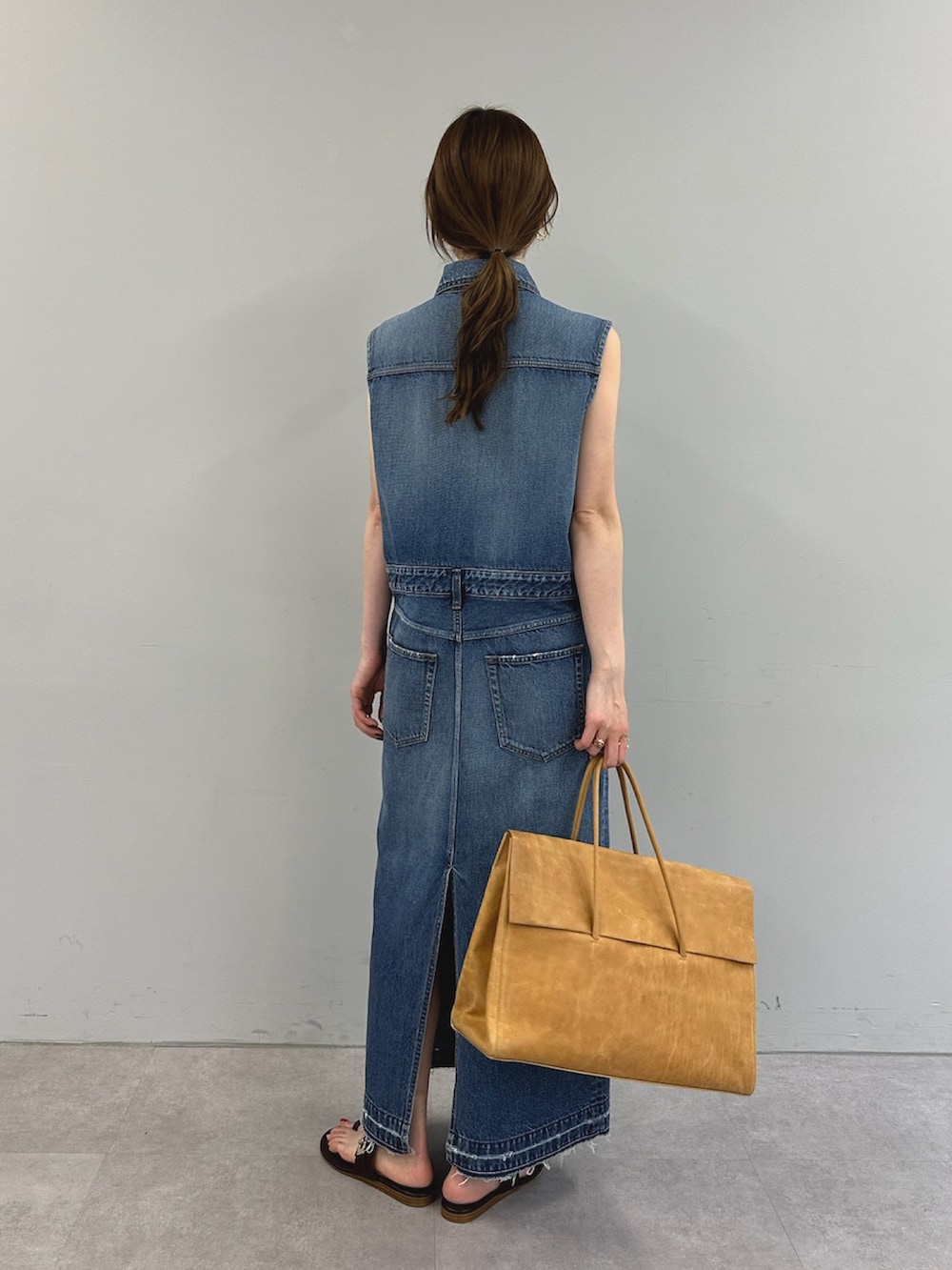 ブルー系のワンピース、イエロー系のボストンバッグを着用したレディースの春コーディネートの4枚目の写真