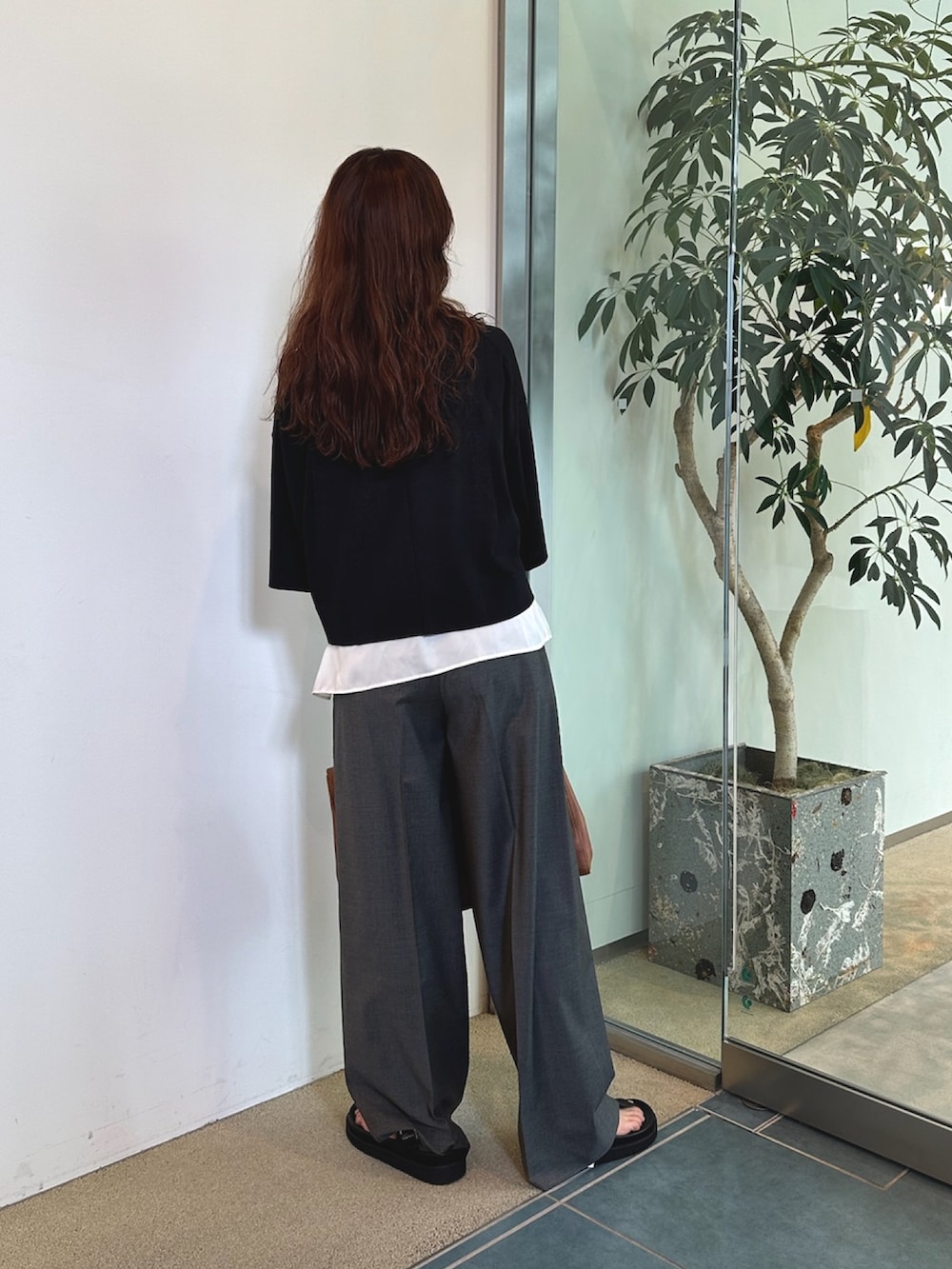 グレー系のスラックス、イエロー系のボストンバッグ、ホワイト系のシャツ/ブラウスを着用したレディースの夏コーディネートの4枚目の写真