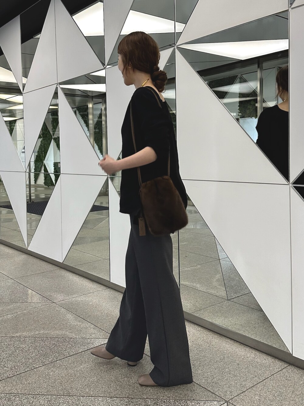 グレー系のブーツ、ブラック系のニット/セーター、ゴールド系のチョーカーを着用したレディースの夏コーディネートの2枚目の写真