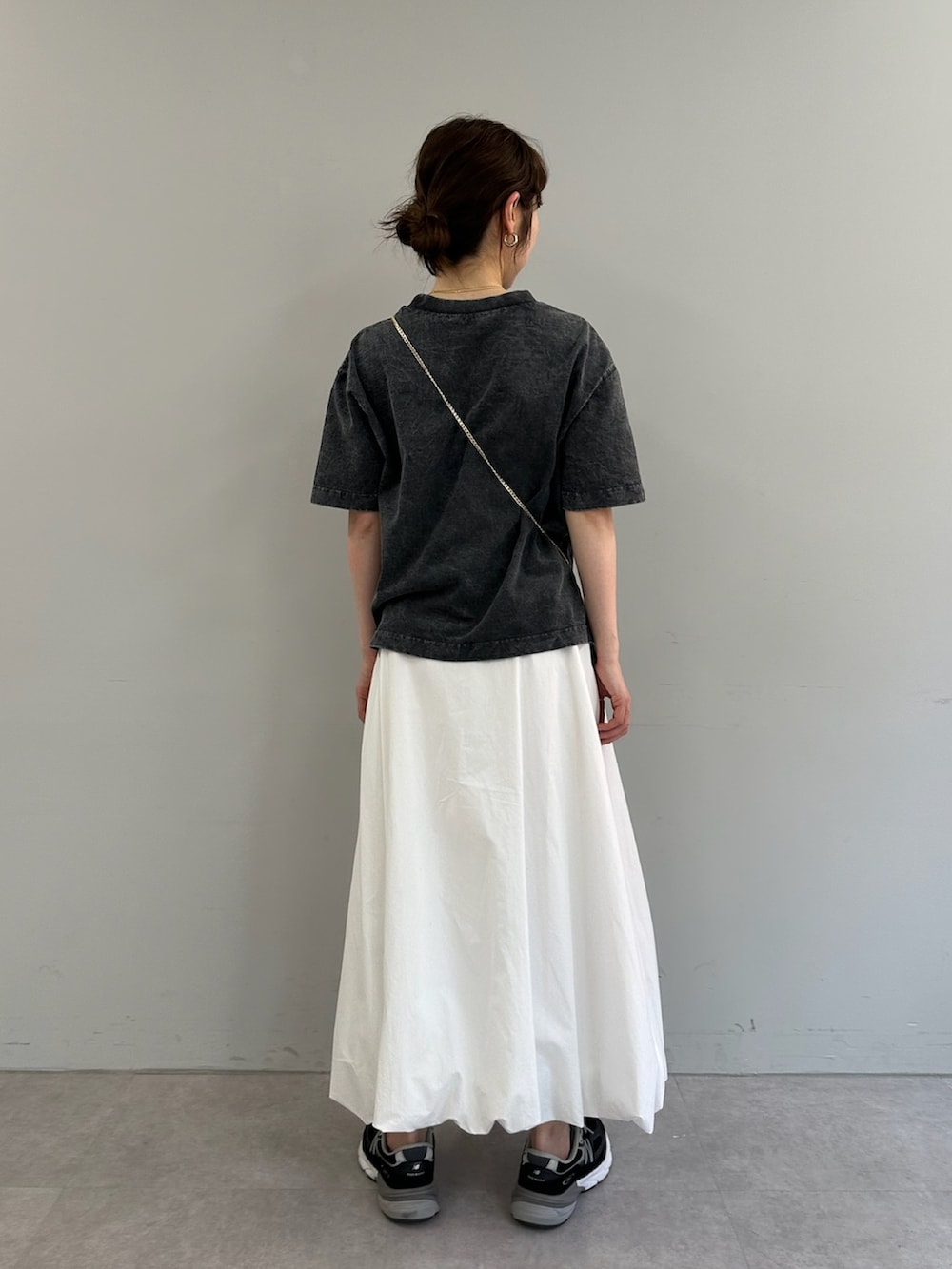ホワイト系のスカート、グレー系のTシャツ/カットソー、ブラック系のショルダーバッグを着用したレディースの春コーディネートの3枚目の写真
