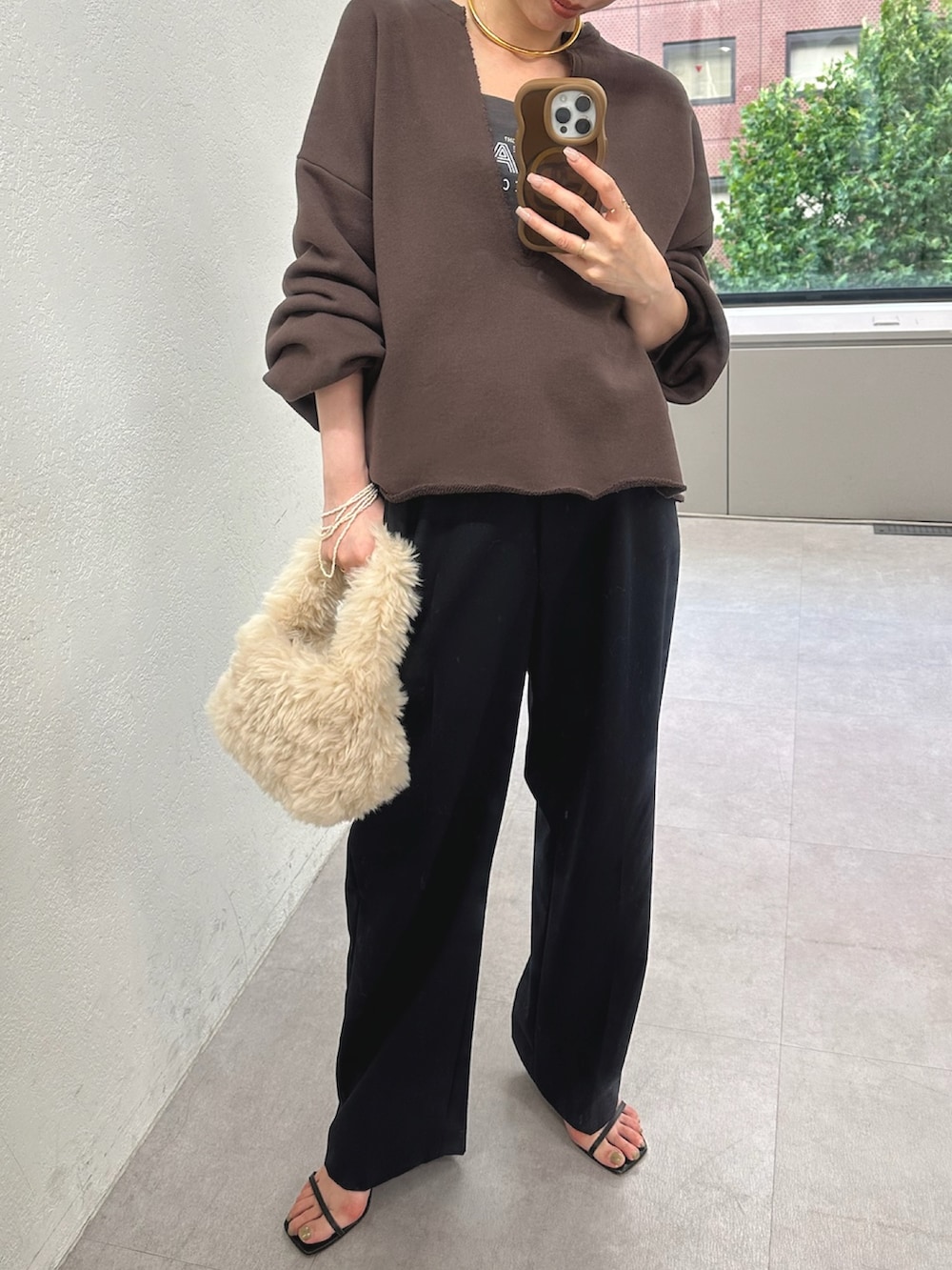 グレー系のスウェット、ホワイト系のハンドバッグ、ブルー系のその他パンツを着用したレディースの秋コーディネートの2枚目の写真