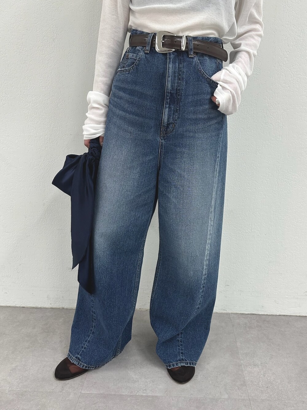 ホワイト系のTシャツ/カットソー、ブルー系のデニムパンツ、ブラウン系のサンダルを着用したレディースの春コーディネートの6枚目の写真