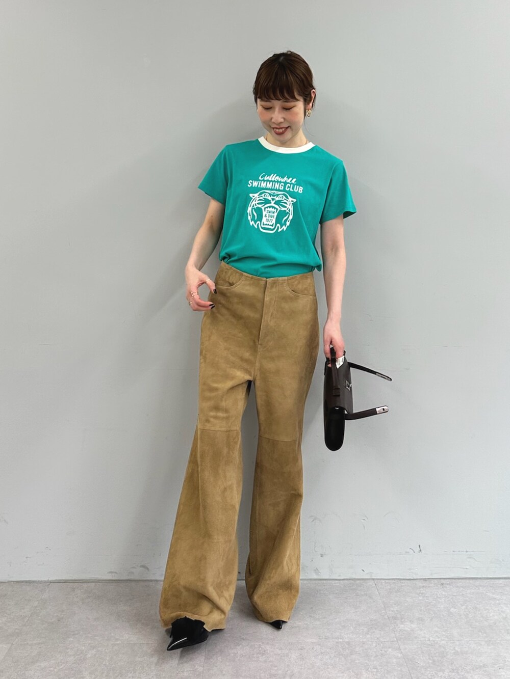 グリーン系のTシャツ/カットソー、イエロー系のその他パンツ、ブラウン系のハンドバッグを着用したレディースの春コーディネートの3枚目の写真