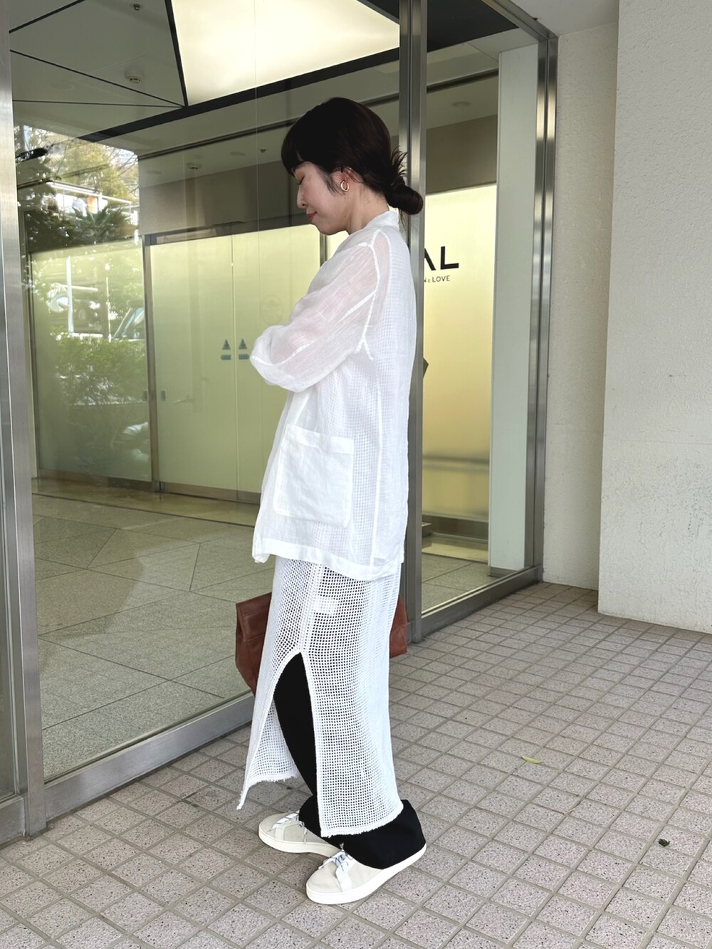 ホワイト系のテーラードジャケット、イエロー系のボストンバッグ、ホワイト系のスニーカーを着用したレディースの春コーディネートの2枚目の写真