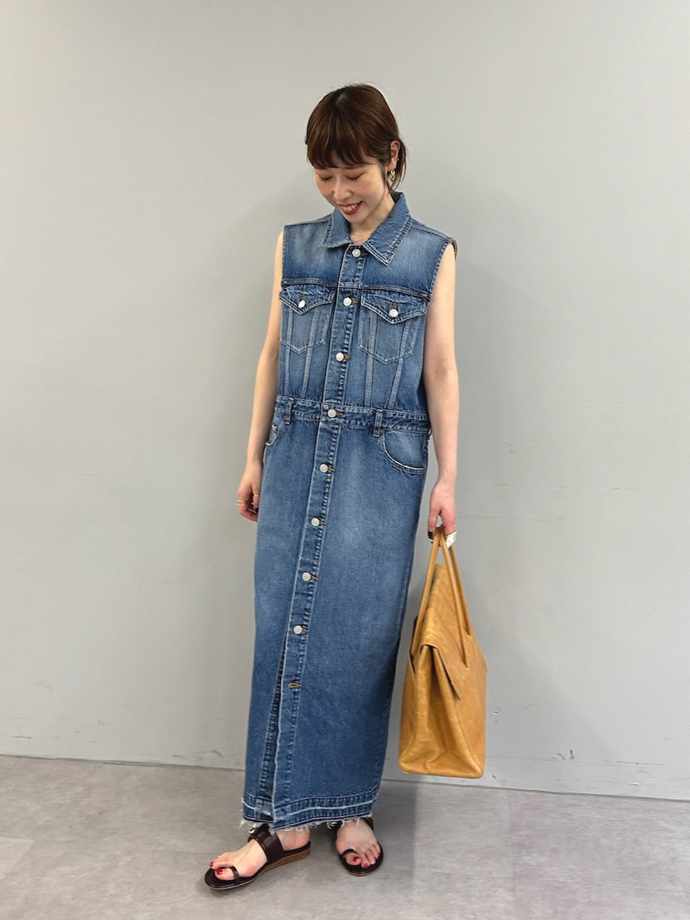 ブルー系のワンピース、イエロー系のボストンバッグを着用したレディースの春コーディネートの2枚目の写真