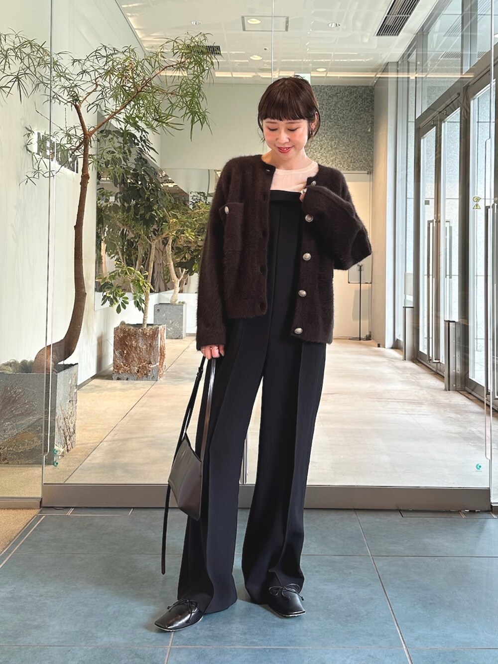 ブラック系のサロペット/オーバーオール、ホワイト系のシャツ/ブラウス、ブラウン系のショルダーバッグを着用したレディースの秋コーディネートの4枚目の写真