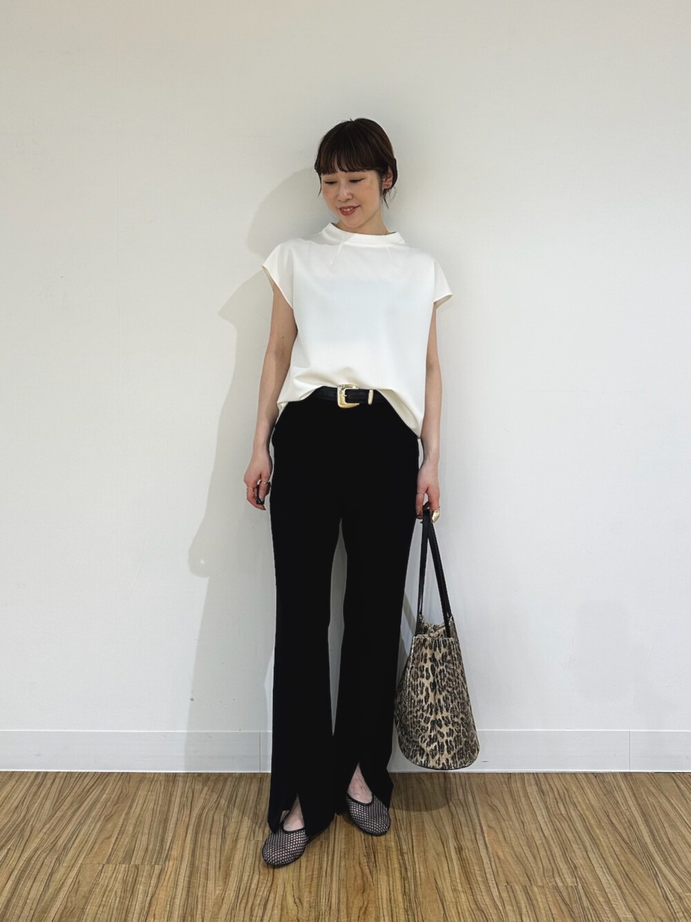 ブラック系のスラックス、ブラック系のパンプス、ホワイト系のシャツ/ブラウスを着用したレディースの夏コーディネートの5枚目の写真