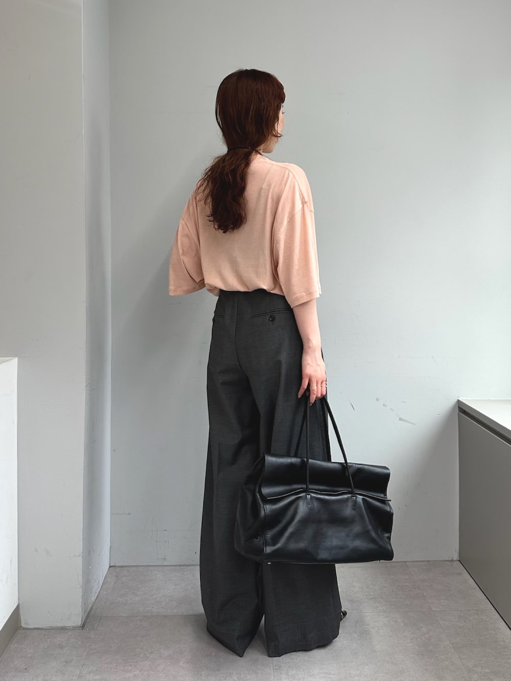 グレー系のスラックス、ブラック系のボストンバッグ、イエロー系のパンプスを着用したレディースの夏コーディネートの5枚目の写真