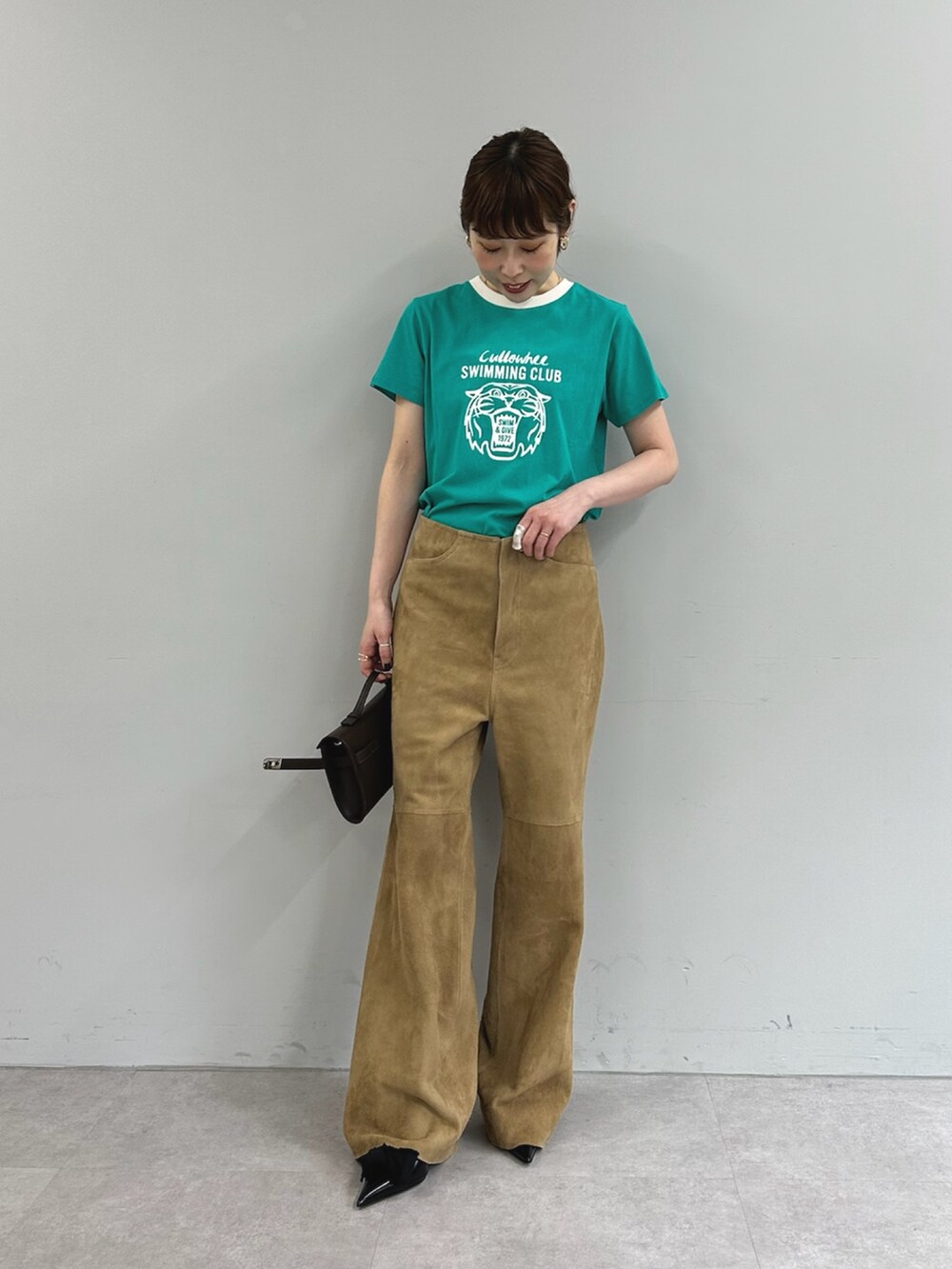 グリーン系のTシャツ/カットソー、イエロー系のその他パンツ、ブラウン系のハンドバッグを着用したレディースの春コーディネートの5枚目の写真