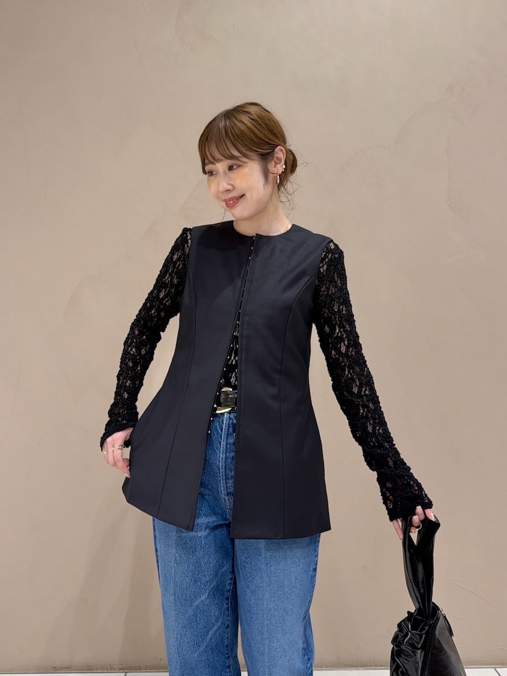 ブラック系のTシャツ/カットソー、グレー系のベスト、ブルー系のベストを着用したレディースの秋コーディネートの6枚目の写真