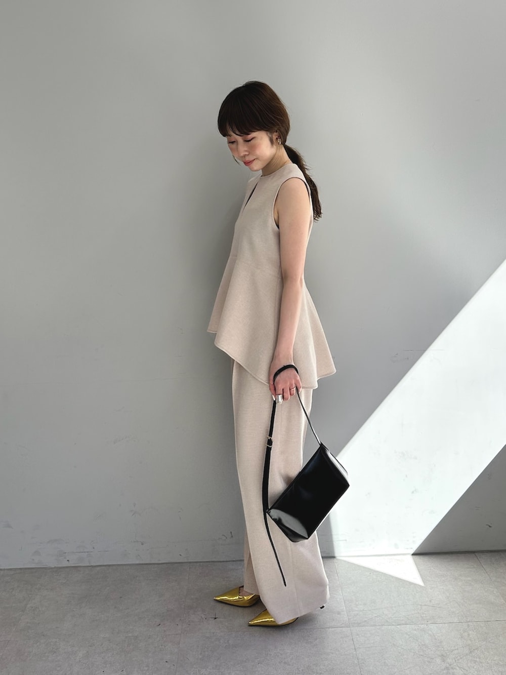 ピンク系のスラックス、ピンク系のシャツ/ブラウス、ブラウン系のショルダーバッグを着用したレディースの春コーディネートの5枚目の写真