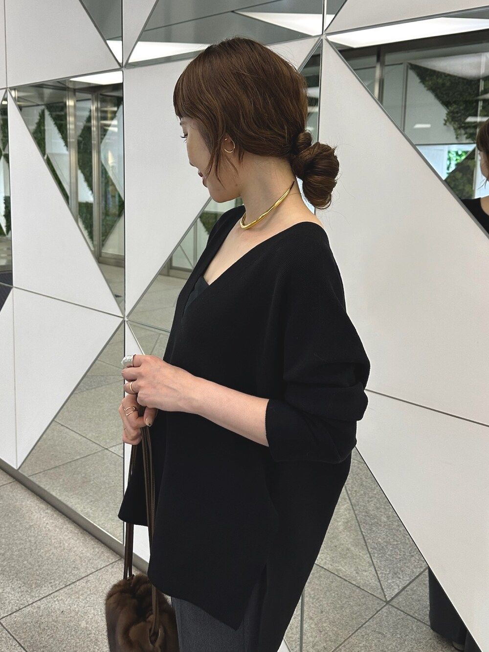 グレー系のブーツ、ブラック系のニット/セーター、ゴールド系のチョーカーを着用したレディースの夏コーディネートの4枚目の写真