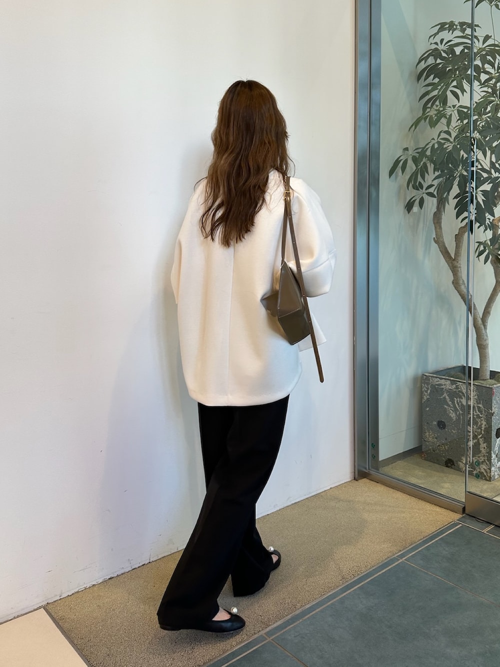 ブラウン系のショルダーバッグ、ホワイト系のTシャツ/カットソーを着用したレディースの春コーディネートの4枚目の写真