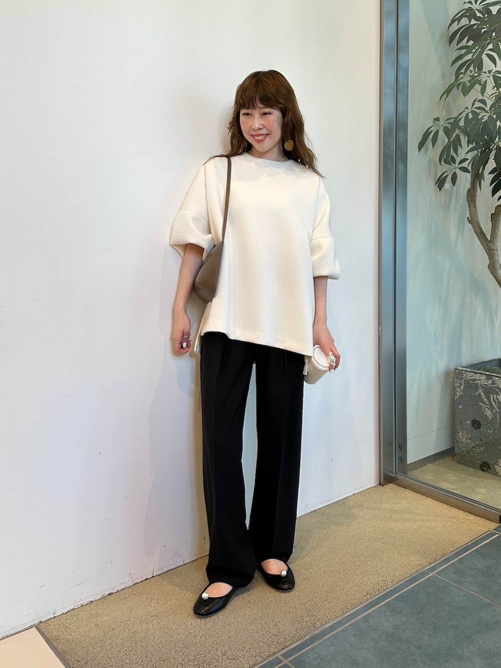 ブラウン系のショルダーバッグ、ホワイト系のTシャツ/カットソーを着用したレディースの春コーディネートの5枚目の写真