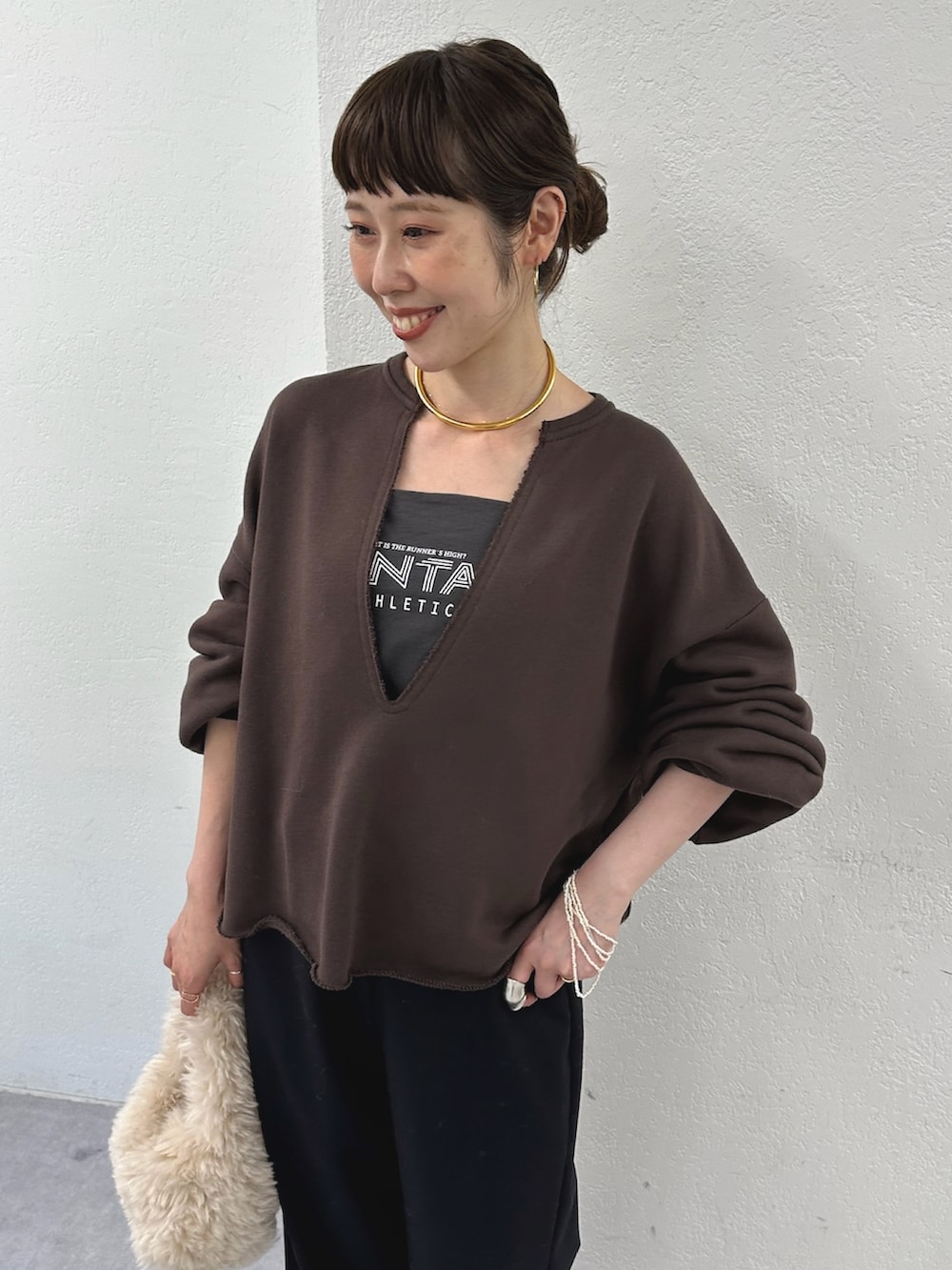 グレー系のスウェット、ホワイト系のハンドバッグ、ブルー系のその他パンツを着用したレディースの秋コーディネートの3枚目の写真