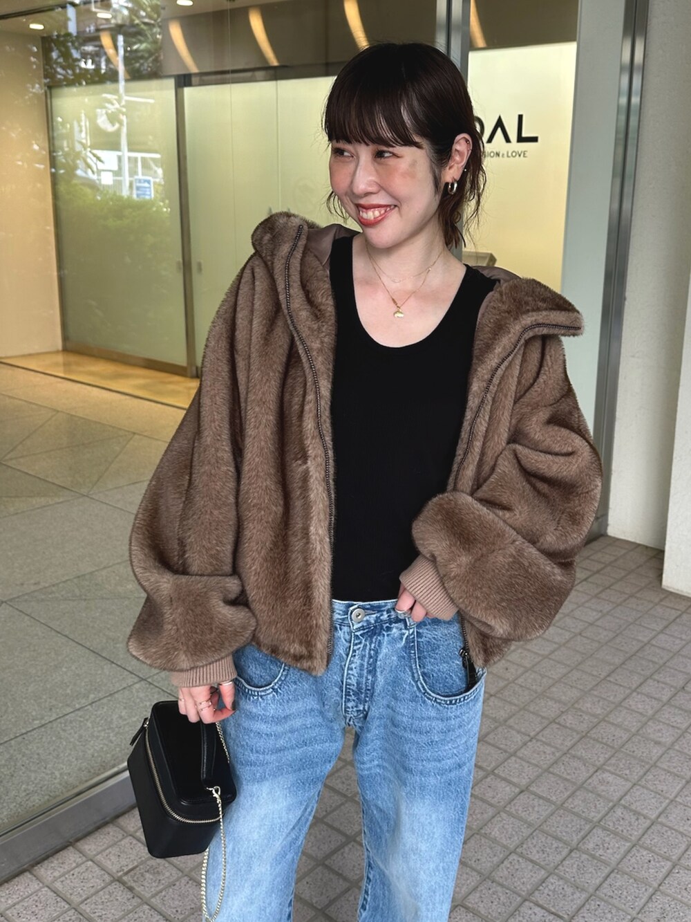 ブルー系のデニムパンツ、ブラック系のショルダーバッグ、ベージュ系のパンプスを着用したレディースの夏コーディネートの6枚目の写真