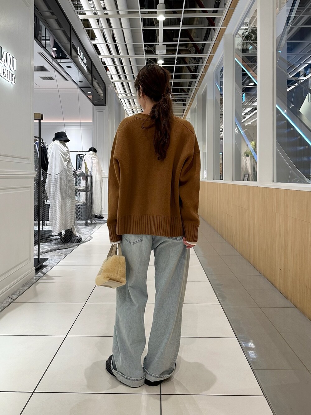 ブラウン系のカーディガン/ボレロ、ブルー系のデニムパンツを着用したレディースの秋コーディネートの5枚目の写真