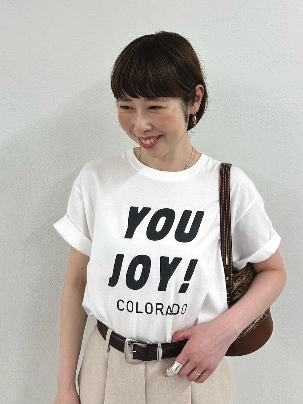 ホワイト系のTシャツ/カットソー、ピンク系のスラックス、ブラック系のパンプスを着用したレディースの春コーディネートの2枚目の写真