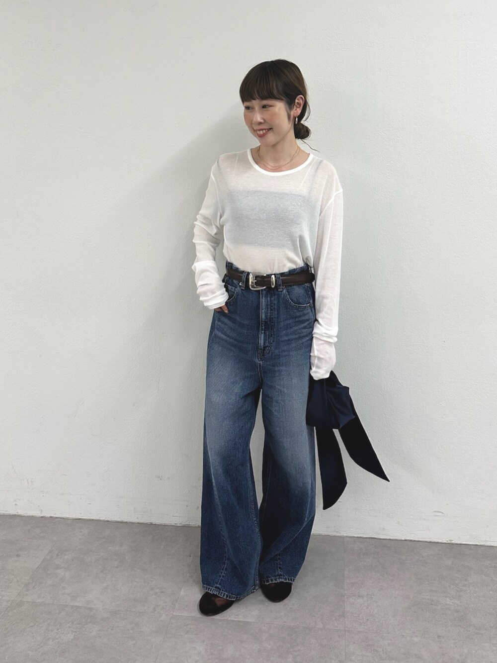 ホワイト系のTシャツ/カットソー、ブルー系のデニムパンツ、ブラウン系のサンダルを着用したレディースの春コーディネートの4枚目の写真