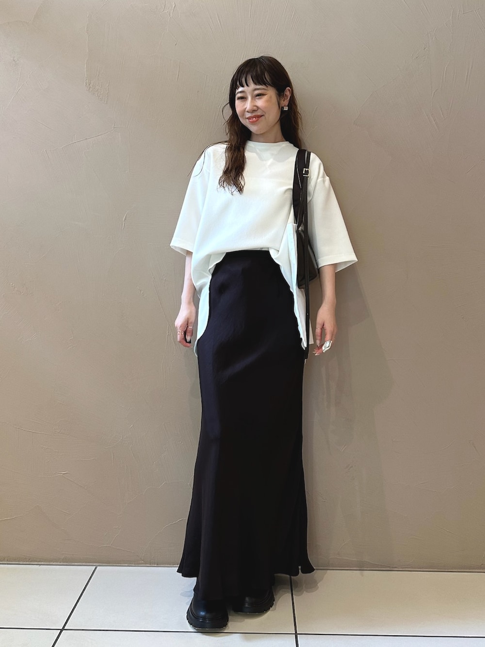 ホワイト系のシャツ/ブラウス、ブラック系のショルダーバッグ、ブラック系のブーツを着用したレディースの夏コーディネートの2枚目の写真