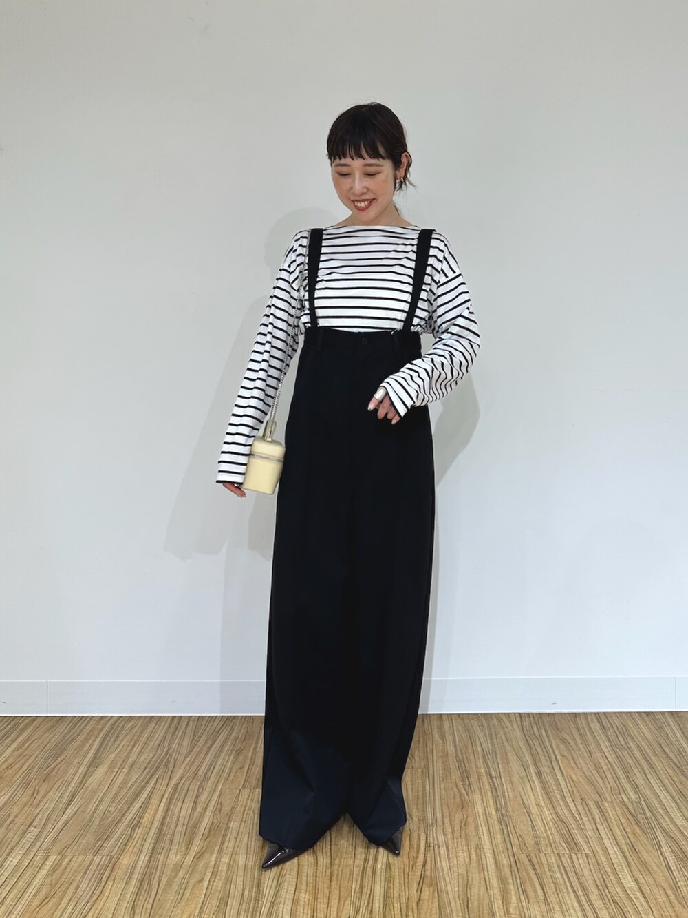 ブラック系のその他パンツ、ホワイト系のショルダーバッグ、ブラウン系のパンプスを着用したレディースの夏コーディネートの4枚目の写真