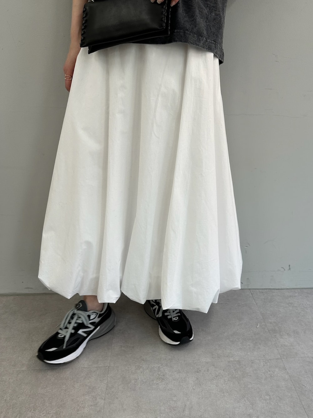 ホワイト系のスカート、グレー系のTシャツ/カットソー、ブラック系のショルダーバッグを着用したレディースの春コーディネートの6枚目の写真