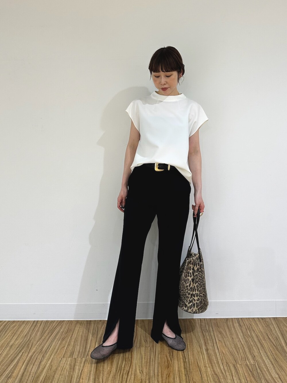 ブラック系のスラックス、ブラック系のパンプス、ホワイト系のシャツ/ブラウスを着用したレディースの夏コーディネートの3枚目の写真