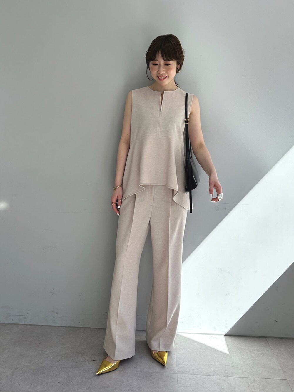 ピンク系のスラックス、ピンク系のシャツ/ブラウス、ブラウン系のショルダーバッグを着用したレディースの春コーディネートの2枚目の写真