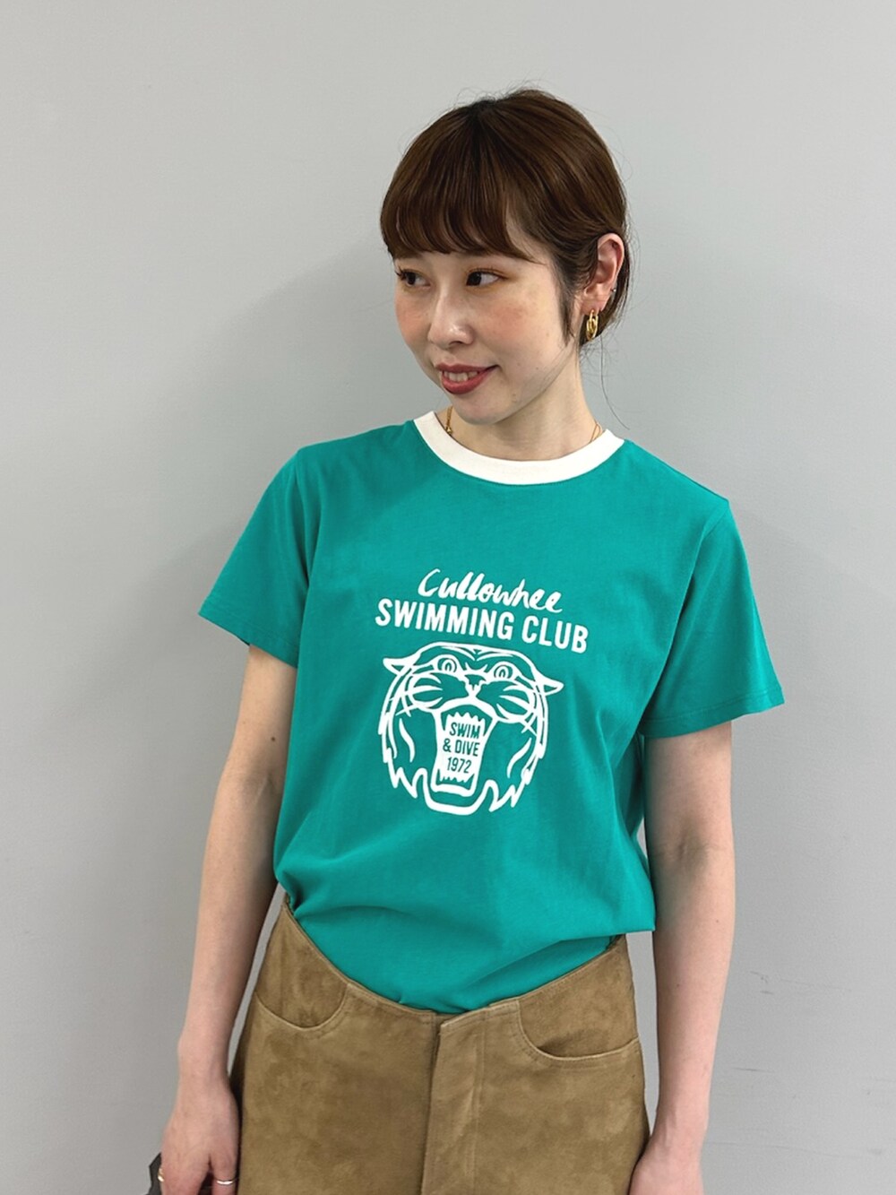 グリーン系のTシャツ/カットソー、イエロー系のその他パンツ、ブラウン系のハンドバッグを着用したレディースの春コーディネートの7枚目の写真