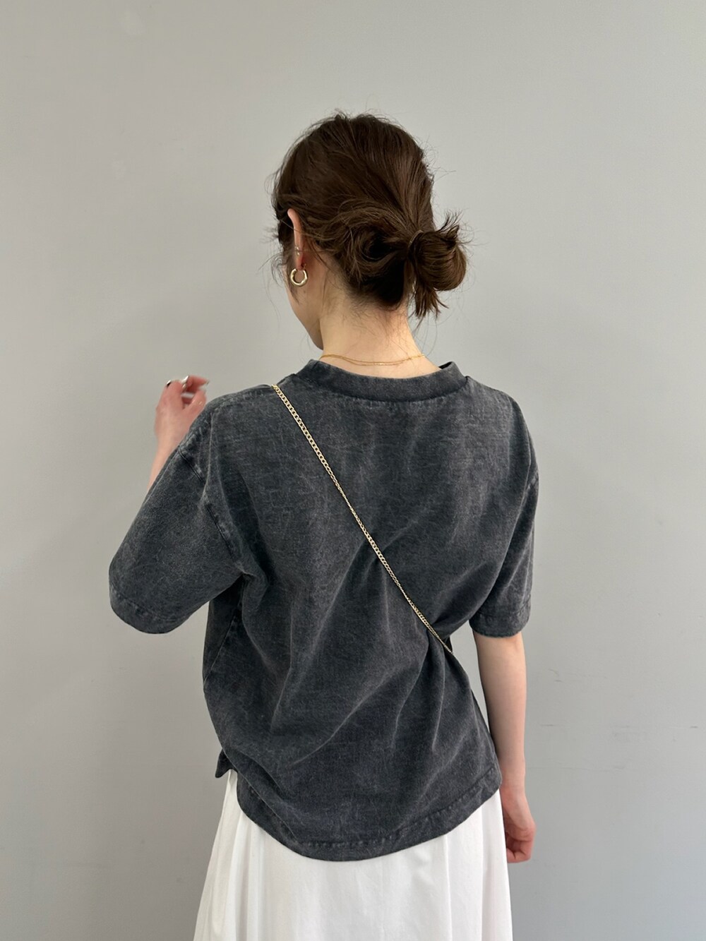 ホワイト系のスカート、グレー系のTシャツ/カットソー、ブラック系のショルダーバッグを着用したレディースの春コーディネートの5枚目の写真