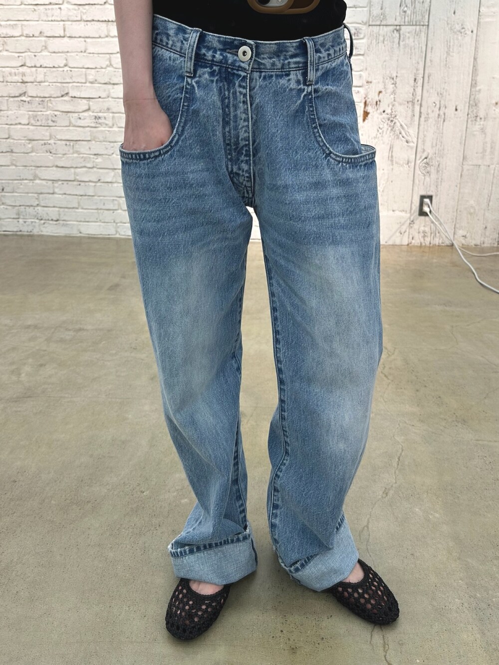 ブルー系のデニムパンツ、ブラック系のショルダーバッグ、ベージュ系のパンプスを着用したレディースの夏コーディネートの7枚目の写真