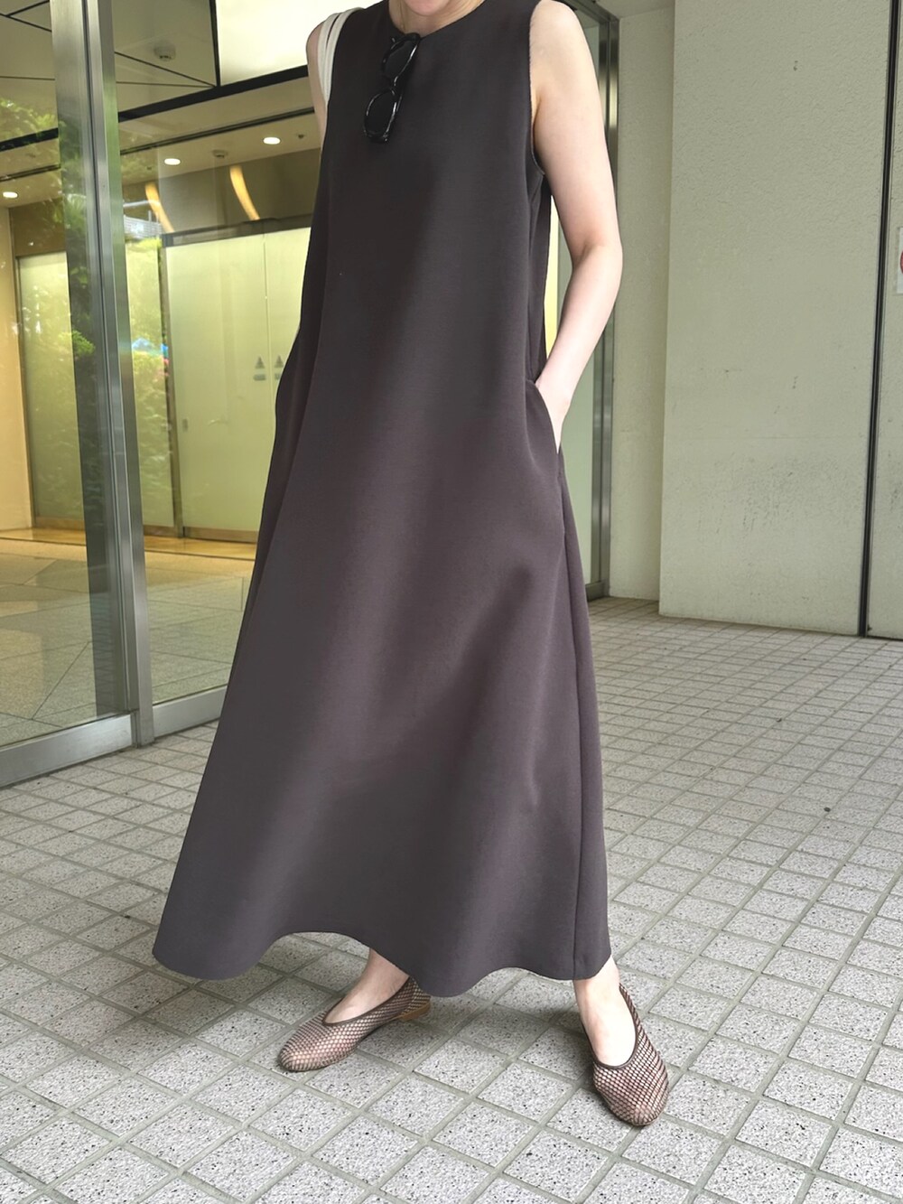 グレー系のワンピース、ホワイト系のハンドバッグ、ブラック系のパンプスを着用したレディースの夏コーディネートの5枚目の写真