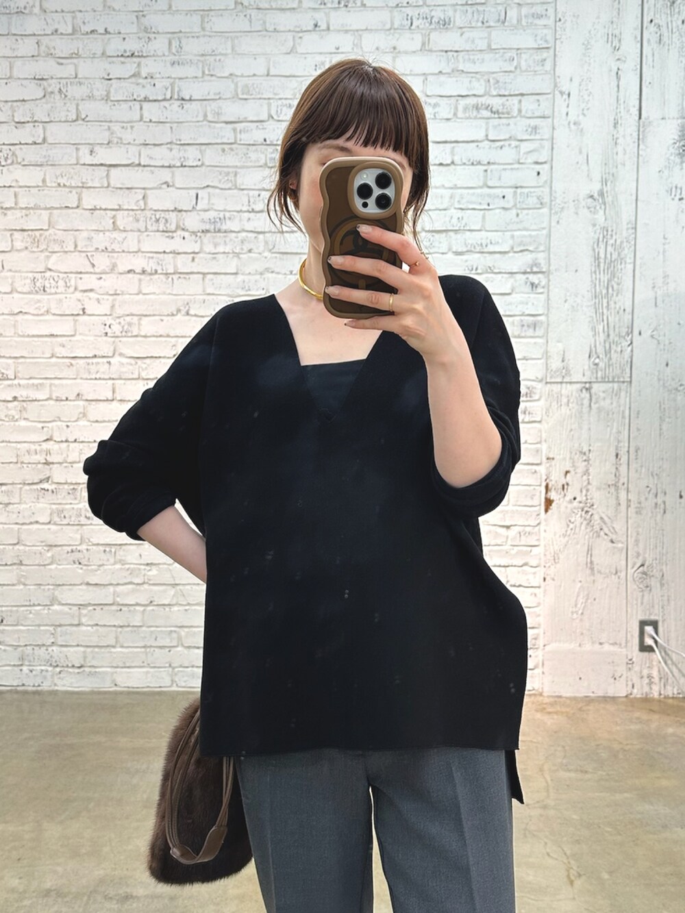 グレー系のブーツ、ブラック系のニット/セーター、ゴールド系のチョーカーを着用したレディースの夏コーディネートの5枚目の写真