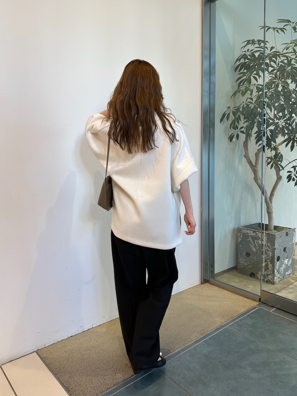 ブラウン系のショルダーバッグ、ホワイト系のTシャツ/カットソーを着用したレディースの春コーディネートの6枚目の写真