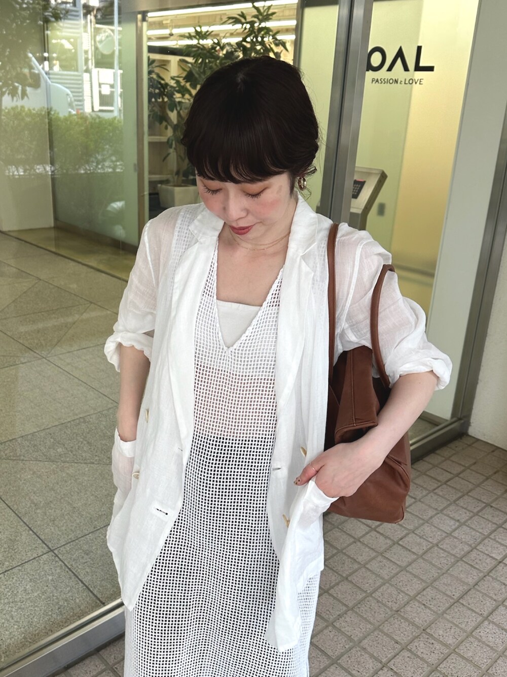 ホワイト系のテーラードジャケット、イエロー系のボストンバッグ、ホワイト系のスニーカーを着用したレディースの春コーディネートの7枚目の写真