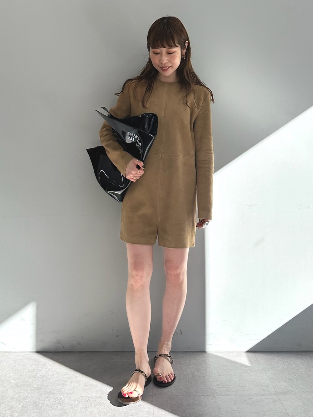 イエロー系のつなぎ/オールインワン、ブラック系のトートバッグを着用したレディースの春コーディネートの2枚目の写真