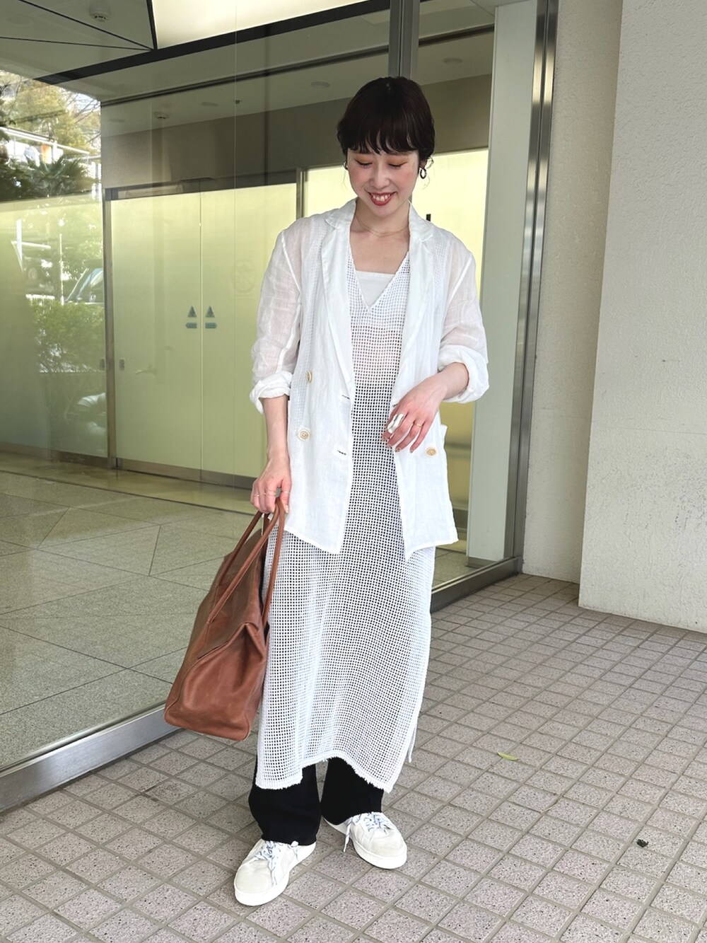 ホワイト系のテーラードジャケット、イエロー系のボストンバッグ、ホワイト系のスニーカーを着用したレディースの春コーディネートの5枚目の写真