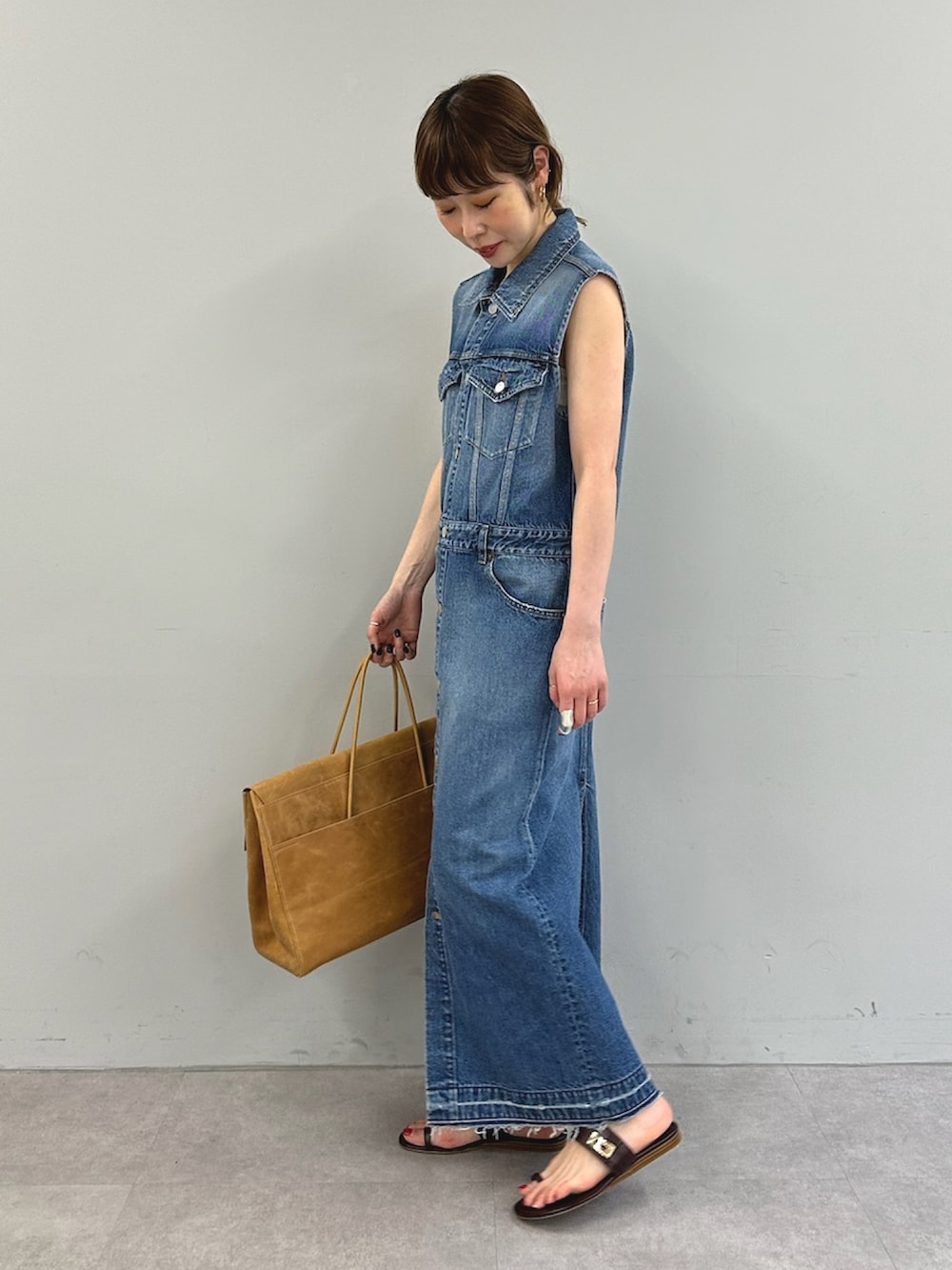 ブルー系のワンピース、イエロー系のボストンバッグを着用したレディースの春コーディネートの3枚目の写真